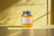 Tea canister labeled 'Shahrah' on a wooden surface with a yellow background