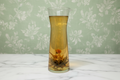 Clear glass vase with floral arrangement on a textured surface