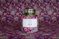 Decorative tea canister with colorful label on a wooden surface