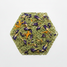 Hexagonal arrangement of green tea leaves with orange and black elements on a white background
