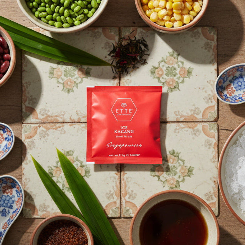 Red tea bag from ETTE Tea Company on a dark surface with leaves and a wooden spoon.