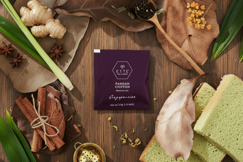 Green tea loaf with dried leaves and tea packaging on a dark surface