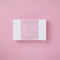 Pink and white product packaging on a pink background